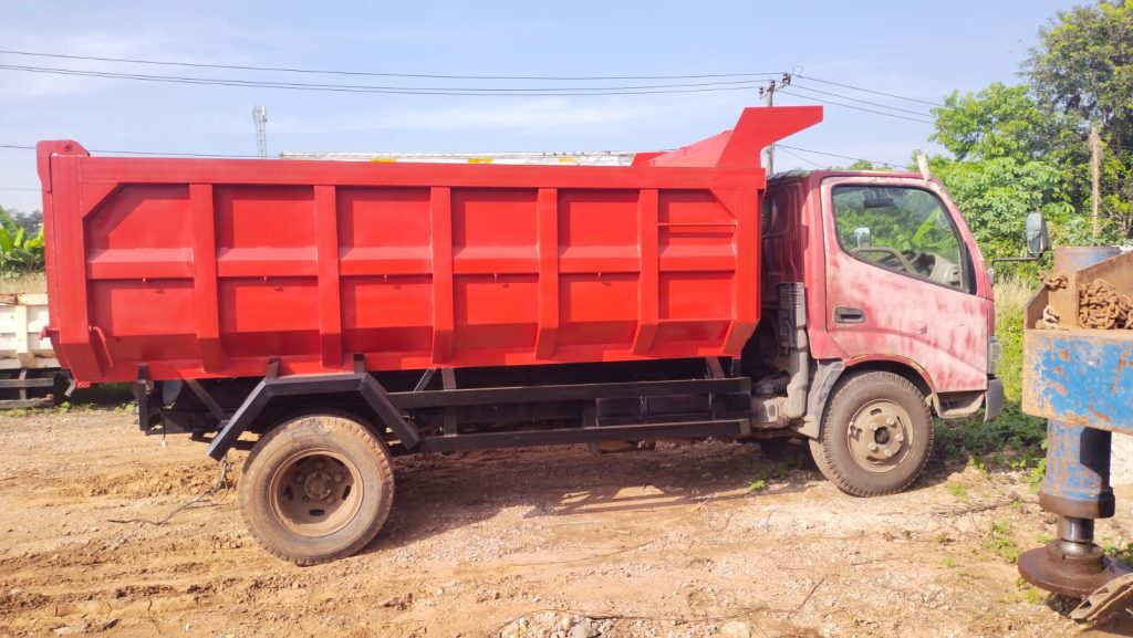Proses pembuatan bak dump truck dengan rangka besi yang kokoh di workshop karoseri