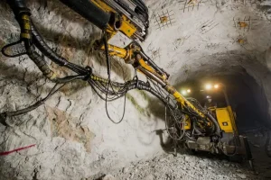 Motor Grader sebagai support equipment mining sedang meratakan jalan tambang